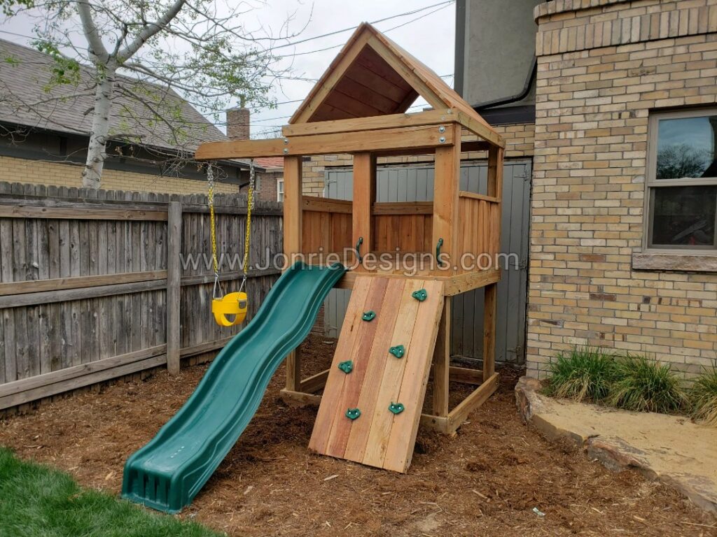5'x5' Clubhouse with wooden roof, 4' Deck height, Standard slide, Rock wall entry, 3' Cantilever with yellow bucket swing