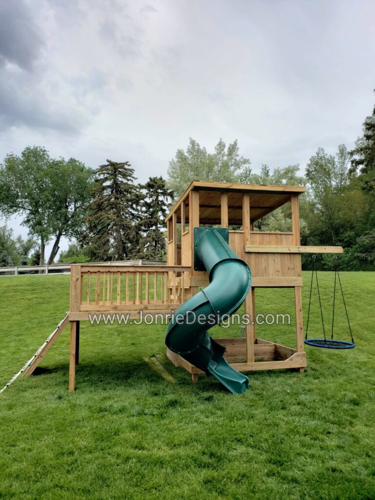 8'x8' Clubhouse with slanted wooden roof, 6' Deck height, 8'x8' Uncovered porch, 4' Deck height, (8'x16' Footprint), 7' Enclosed spiral slide, 3' Cargo net & Rock wall entry, 3' Cantilever with Web swing & 4'x8' Framed sandbox